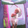 Little girl standing inside the play tent.